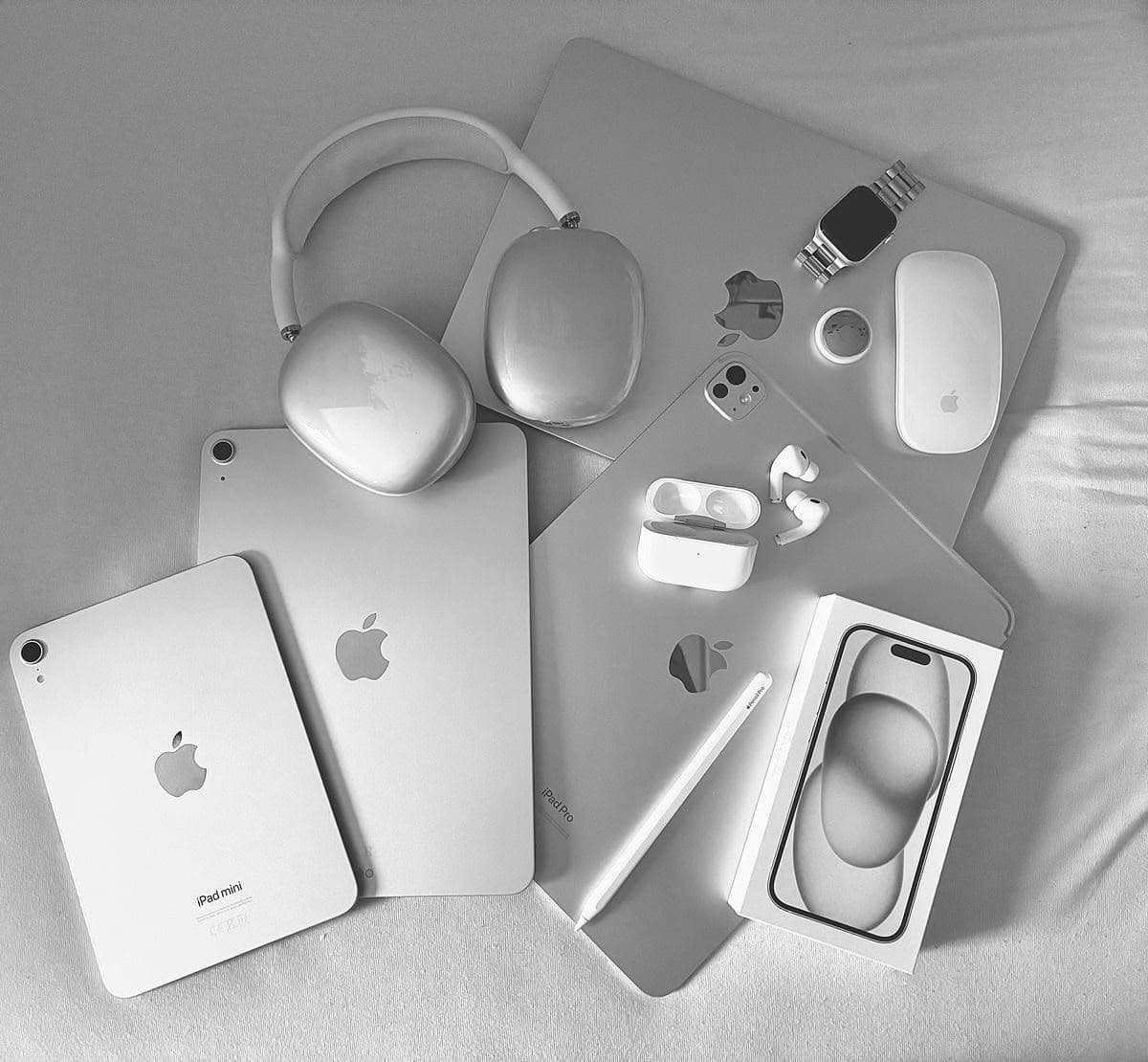 Produits Apple en noir et blanc : iPad, AirPods Max, MacBook, iPhone et Apple Watch
